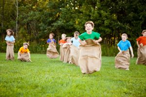 Happy Kids Having Potato Sack Race Outside