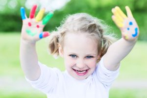 child with colourful hands